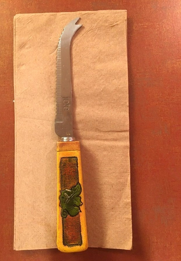 Photo of a cheese knife with two-pointed, clawed end for picking up cheese from a cheese board